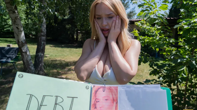 Millie covers her face with both hands as the reality of the debt sinks in